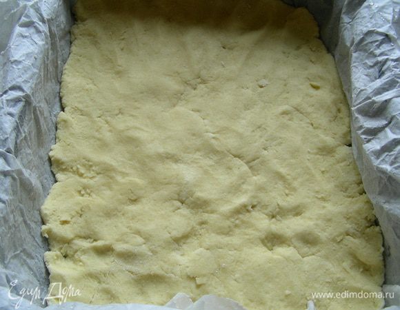 Форму выстилаем бумагой для выпечки и распределяем по ней наше тесто. Удобно это делать руками, их надо немного присыпать мукой. Выпекаем тесто в духовке 180 гр 15 минут.