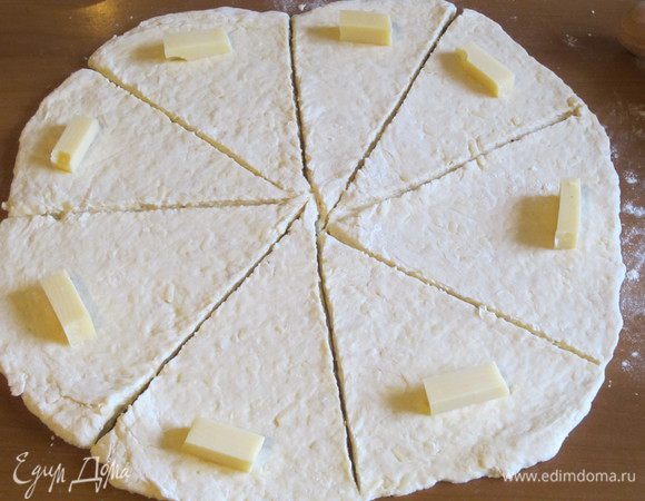 На рабочей поверхности,присыпанной мукой,раскатать тесто и  разделить на 8-10 треугольников.На край треугольника положить кусочек сыра.