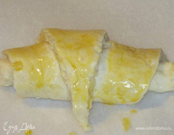 Венчиком взбить желток с молоком. Выложить булочки на противень с пергаментом,смазать яично-молочной смесью и отставить на 30 минут на расстойку. 