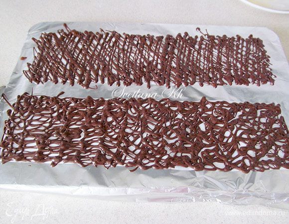 Для шоколадной ленты нужно отмерить длину десерта в охвате  и его высоту. вырезать ленту по размеру. Я всегда беру на 1-2 см выше.
На ленту нанести узор или полоски темным и светлым шоколадом. У меня вышло очень неуклюже, так как, рисунок потом смазался. В комнате было очень тепло и шоколад не хотел застывать. Пока я его переносила с одного места на другое, лента  зацепилась и смазалась. Это фото из другого десерта, без белого шоколада, но принцип тот же.
