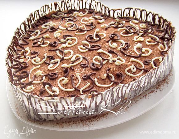 Когда шоколад немного схватится, перенести  бумажную ленту  с  шоколадным рисунком на края десерта, соединить ее, прижать. Поставить в холодильник на пол часа. Затем освободить от бумаги. Дать хорошенько пропитаться десерту в холодильнике, лучше оставить его на ночь.