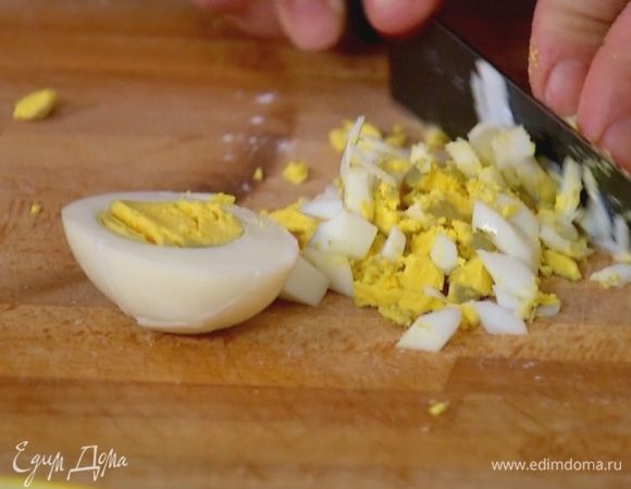 Сварить вкрутую 2 яйца для начинки, затем почистить и мелко порубить.