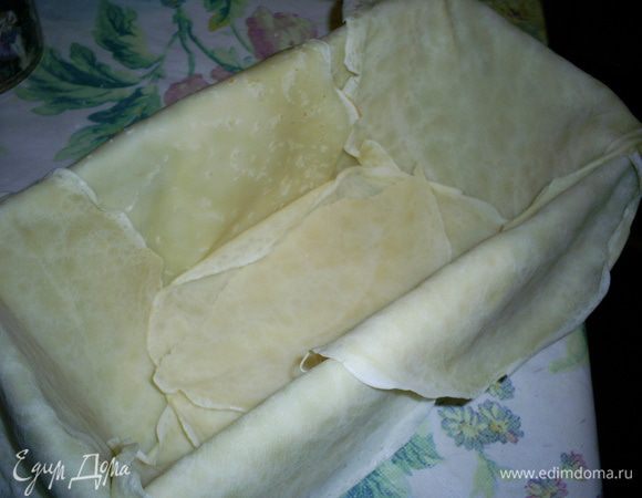 Теперь приступаем непосредственно к формировке пирога. Высокую прямоугольную форму (у меня трапецевидная) для выпечки кексов щедро смазываем маслом и выстилаем внахлест блинчиками так, чтоб их края свисали. У меня на это ушло 7 блинчиков.