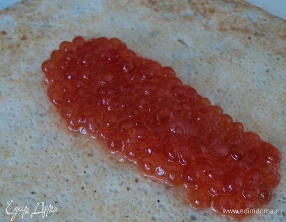 Берем блинчик, сбрызгиваем несколькими каплями лимонного сока, выкладываем на него немного икры, заворачиваем в рулетик. Также поступаем с остальными блинчиками, пока не закончится икра:)