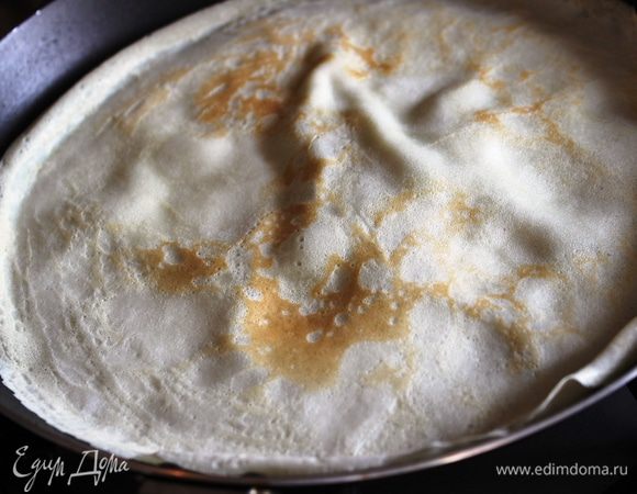 Испечь блины: для этого совсем небольшим количеством растительного рафинированного масла смазать сковороду, налить тесто и распределить его по сковороде так, чтобы блин получился тонким, но без дырочек. Через минуту перевернуть и обжарить с другой стороны. Смазывать маслом готовые блины не нужно!