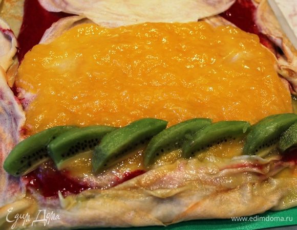 Один киви очистить и разрезать на дольки...уложить их на один край в ряд и начать заворачивать рулет (с того конца, где расположены кусочки киви). Эта процедура показалась мне самой сложной во всем процессе приготовления))) начинка все время пыталась сместиться и ускользала из-под блинов))) Но ничего страшного...надо набраться терпения и очень аккуратненько, не торопясь, свернуть блины (особо сильно их не прижимать)