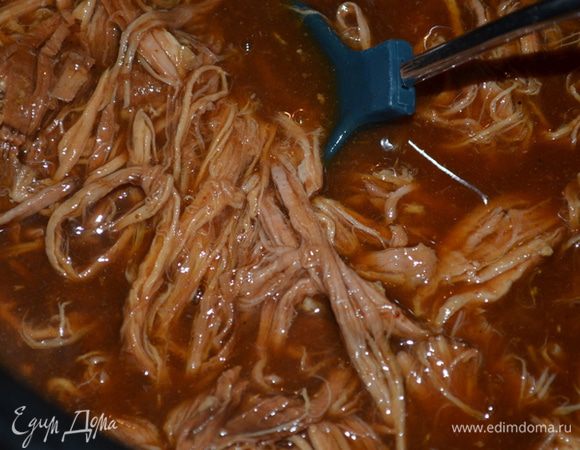 Готовая свинина распадается легко при прикосновении вилки. Выкладываем поверх булочки мясо, на каждую порцию выкладываем соус барбекю  из бутылки.