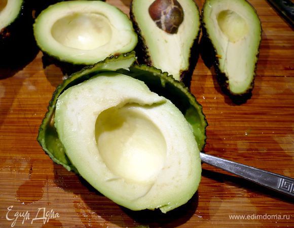 Разогреваем духовку до 180 градусов. Чайной ложкой извлекаем косточку из авокадо и также ложкой отделяем кожуру от мякоти. 