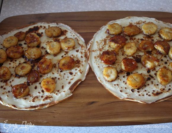 Теперь берем доску,кладем на нее два блина,выкладываем на них бананы