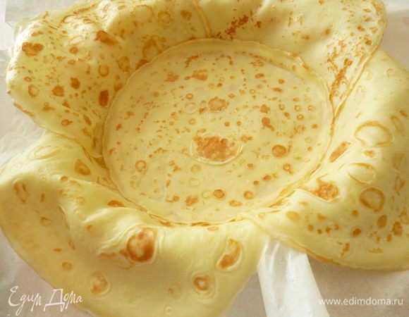 Берем форму для запекания (у меня из фольги). Бумагу для выпечки смочить водой и сложить в два слоя (так пирог не будет пригорать), выстелить форму,что бы края бумаги были немного выше формы.Выкладываем по кругу блины внахлест,что бы края свисали за край формы,а нижняя часть блина заходила на дно формы.Посередине кладем 2 блина один на другой.