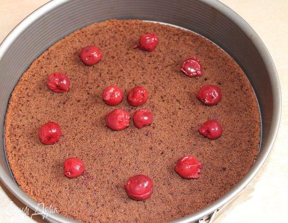 я добавила еще вишни с банки... оставались... Этот бисквит пропитывать не нужно, он достаточно влажный. Итак, берем ровно половину крема и выкладываем его на торт, сверху 2-й бисквит, и заливаем все кремом..