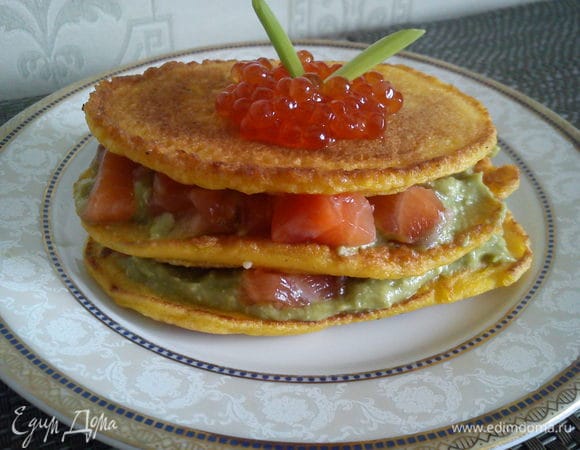Смазать блинчик соусом из авокадо и выложить кусочки семги. Положить на него еще один такой же. Сверху накрыть третьим блинчиком и украсить его икрой.