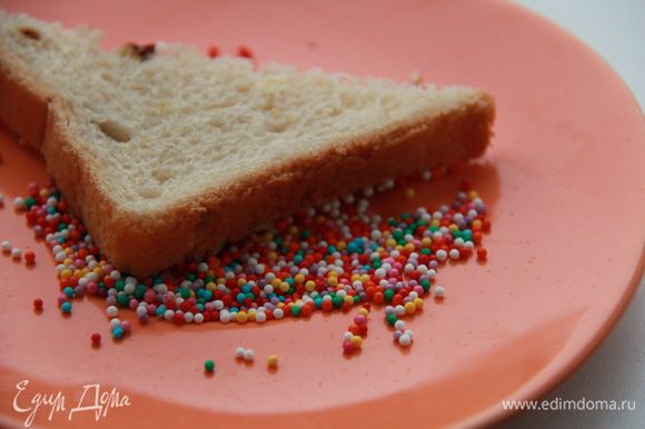 Намажьте хлеб сливочным маслом и разрежьте по диагонали. Обмакните смазанной стороной в тарелку с конфетти.