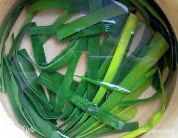 Разрезать каждый лист лука-порея на 3-4 продольные полоски, затем нарезать их отрезками 12-14 см. Вскипятить в кастрюле воду, опустить в неё на 2 мин зелёные листья лука-порея. Затем с помощью шумовки переложить их в миску с холодной водой. Затем выложить листья на бумажные салфетки.