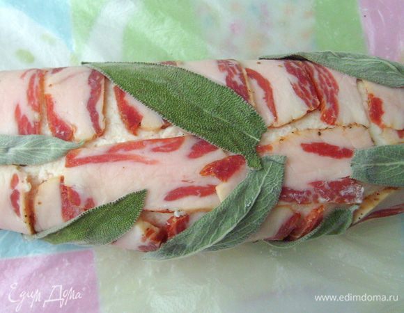 Поверх бекона уложить сформированный куриный рулет, плотно обернуть его беконом. Сверху выложить листья шалфея.