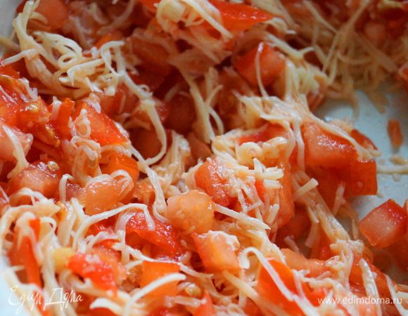 Начинка для рулетиков: Сыр натереть на мелкой терке, помидоры порезать небольшими кубиками, выдавить чеснок. Смешать все в одной чашке, посолить и поперчить.