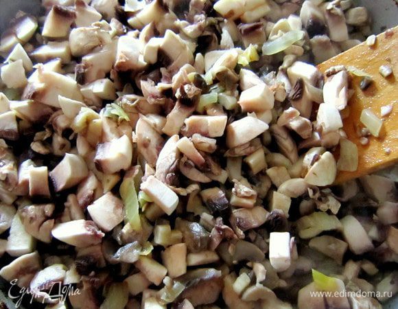 Грибы мелко нарезать и добавить к луку. Добавить сметану, подсолить и перемешать. Протушить в течение 15 мин. 