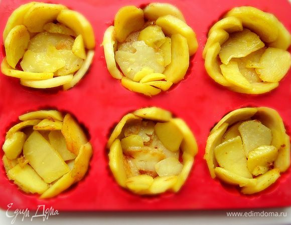 Фому  для маффинов или тарталеток  смазать растительным маслом, присыпать манкой или панировочными сухарями. Ломтики картофеля выложитьна дно формочек, а также по кругу формы в виде лепестков.