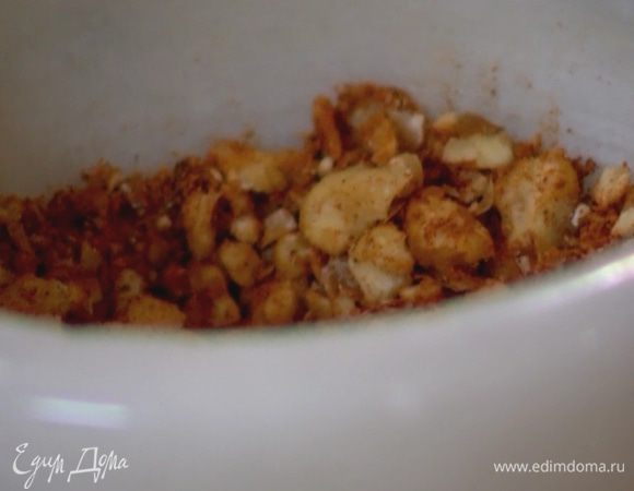 Грецкие орехи добавить в ступку и измельчить их.