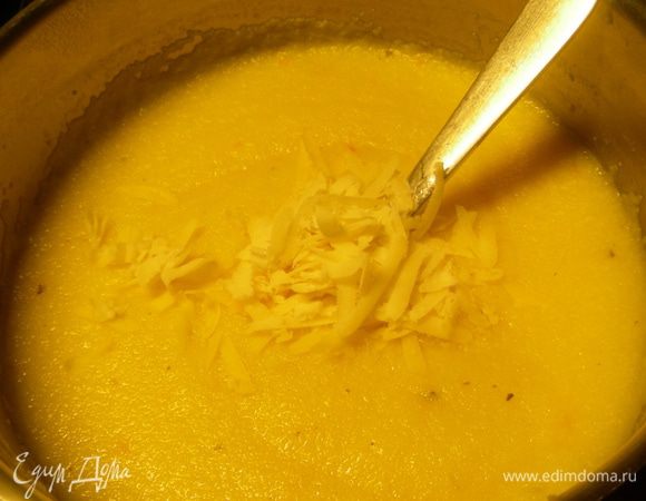 В кастрюле доводим до кипения овощной бульон и понемногу вcыпаем поленту, постоянно помешивая. Готовим ее на небольшом огне минут 5, все время помешиваем. Она должна сильно загустеть. Снимаем с огня. Добавляем 1 ст.л. тертого пармезана. Перемешиваем.
