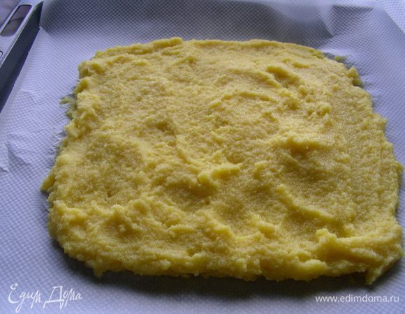 Берем противень, выстилаем его бумагой для выпечки. Выкладываем на него поленту слоем средней толщины. Желательно ее оставить на некоторое время, чтобы она затвердела (в идеале хорошо ее поставить в холод). Тогда она будет хорошо держать форму.
