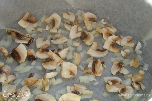 Форму застилаем пергаментом и смазываем растительным маслом. На дно формы выкладываем половину измельченного лука и все грибы.