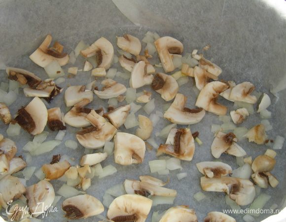 Форму застилаем пергаментом и смазываем растительным маслом. На дно формы выкладываем половину измельченного лука и все грибы.