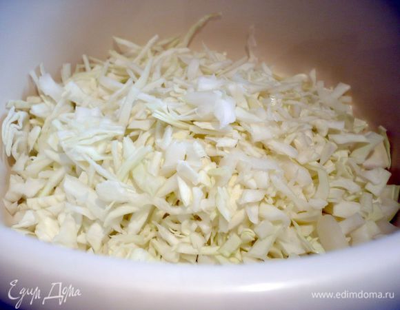 Заквасим капусту, для этого мелко порубим ее, посолим, помнем ее руками, чтобы она дала сок, и зальем горячей сывороткой. Оставим под пленкой при комнатной температуре постоять, у меня она настаивалась почти сутки. Затем откинем капусту на сито и дадим лишней жидкости стечь. Получается очень нежная солоноватая капуста, хрустящая и с кислинкой.