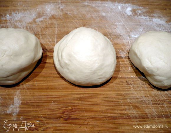 Посыпаем рабочую поверхность слегка мукой и месим тесто буквально пару минут, затем начинаем с силой ударять им об стол, я проделала эту процедуру 100 раз, по рецепту должно хватить и пятидесяти ударов. Тесто становится почти воздушное и к рукам липнуть почти перестает. При его раскатывании нам все равно понадобится присыпать поверхность мукой. Делим его на три равные части и убираем в холодильник (я немного присыпала дно контейнера мукой, но, думаю, достаточно было бы присыпать немного мукой само тесто) на 1 час (первый кусочек я достала уже через три четверти часа).