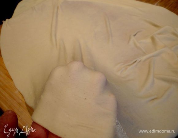 Теперь подкладываем руки, ладонями вниз (или кулаки), под края теста и начинаем, слегка потрясывая его, поворачивать тесто по кругу и растягивать. Этот прием я подсмотрела у своей подруги из Австрии, когда она у нас в гостях (я тогда еще студенткой была) готовила штрудель.