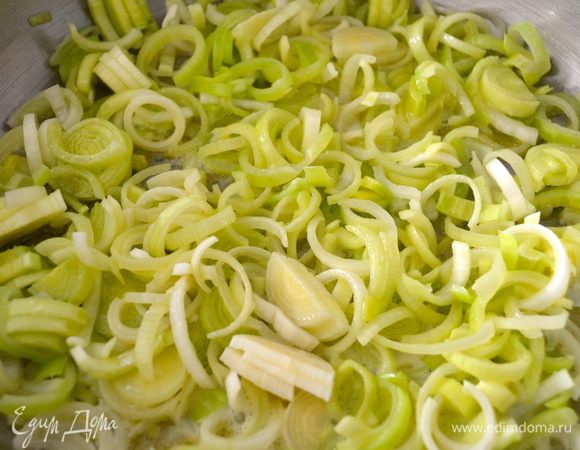 Лук-порей нарезать полукольцами... Вместительную сковороду поставить на огонь. Положить сливочное масло и добавить оливковое. Выложить в сковороду и начать пассеровать лук порей, постоянно помешивая и не давая ему зажариться.   