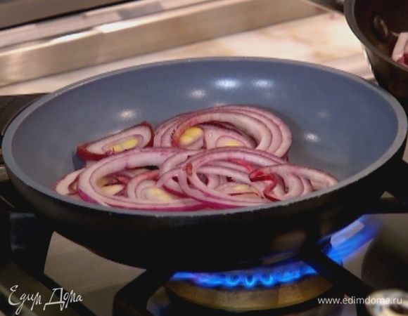 В отдельной сковороде разогреть оставшееся оливковое и сливочное масло, выложить лук, нарезанный кольцами, и дать ему закарамелизироваться.