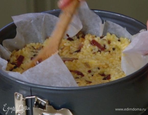 Небольшую форму выстелить бумагой для выпечки, смазать растительным маслом и равномерно распределить рисовую массу.