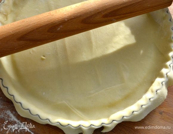 Скалкой пройтись по краю формы и обрезать лишнее тесто (или сделать это просто ножом)