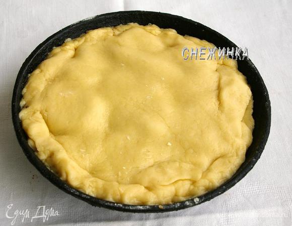 На присыпанной мукой поверхности раскатываем тесто в круг, чтобы по диаметру оно было немного больше диаметра формы (сковороды). Накрываем тестом киви и немного подворачиваем края.