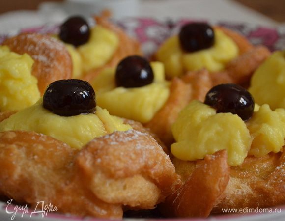 Осталось всего-ничего. Пончики выкладываем на сервировочное блюдо и в центр каждого кладем немного заварного крема. Поверх крема украшаем вишенкой из сахарного сиропа (или варенья). В конце можно еще присыпать слегка сахарной пудрой... Это именно традиционное украшение zeppole ))  