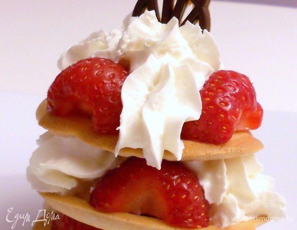 На нижний креп положить 3 кусочка клубники, между ними поместить взбитые сливки и повторить так ещё 2 раза. Получится башенка.