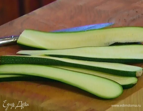 Цукини нарезать вдоль длинными полосками толщиной 0,5 см и слегка смазать оливковым маслом.