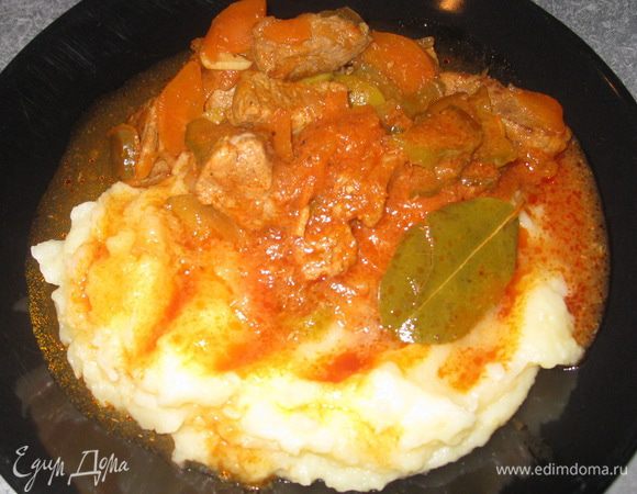 Нарезаем говядину небольшими кусочками. На разогретую сковороду добавляем растительное масло, обжариваем говядину (пока не выкипит жидкость). Добавляем соль и перец. Нарезаем морковь и лук полукольцами, добавляем к мясу и обжариваем всё вместе 10 минут. Заливаем водой, добавляем томат, доводим до кипения, убавляем огонь - тушим под крышкой 30 минут. Мелко шинкуем чеснок, нарезаем соленые огурцы полукольцами, оливки - кольцами. Добавляем чеснок, огурцы, оливки и лавровый лист к мясу. Тушим 20 минут на среднем огне.