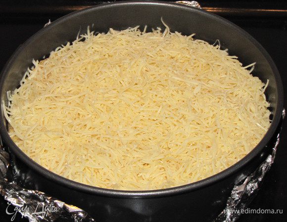 Выньте форму  из духовки и посыпьте пирог тертым сыром. Поставьте обратно в духовку на 15 минут до зарумянивания сыра.