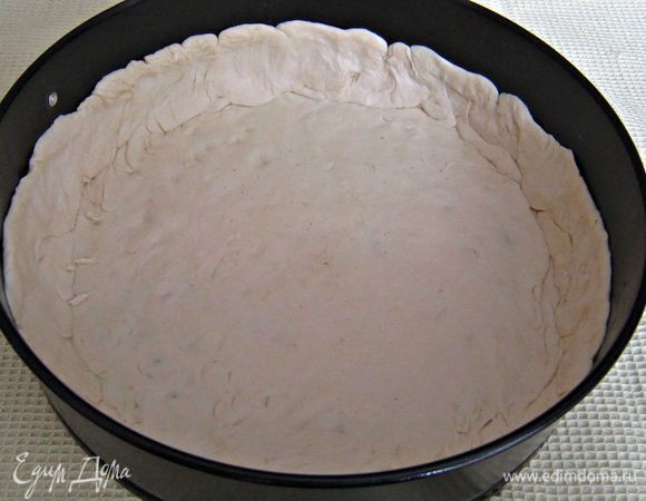 Разъемную форму (диаметром 28 см) смазать растительным маслом.
Тесту придать форму круга, выложить в форму и сформировать высокие бортики.