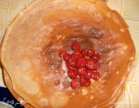 На край блинчика кладем вишни (у меня консервированные в собственном соку, но можно абсолютно любые - замороженные, свежие, хоть из варенья) и сворачиваем треугольничком