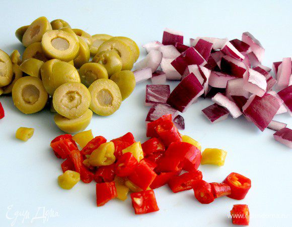 Пока запекается картофель, порежьте оливки на кружочки. Лук и перец порежьте на кусочки размером примерно 1 см.