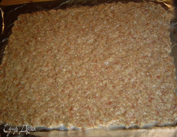 Фольгу слегка смазываем растительным маслом, а затем выкладываем подготовленный фарш и разравниваем.