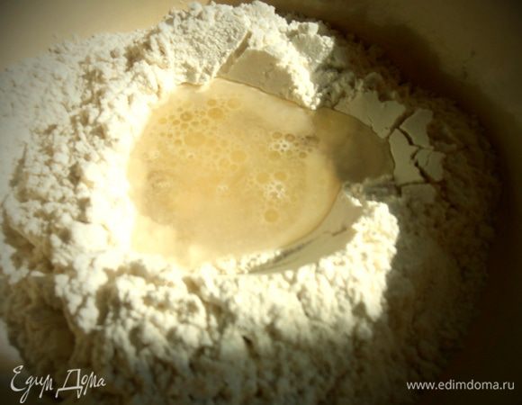 Вливаем тёплую воду с солью и замешиваем тесто.