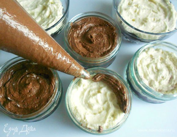 Поверх пропитанного бисквита распределить сначала белый крем, затем шоколадный. Можно, конечно, и ложкой выкладывать, но мне легче дозировать из кондитерских мешков.