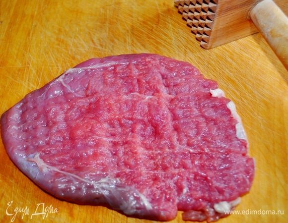 Говядину тонко нарезать, направляя нож поперек волокон, то есть так, чтобы получились отбивные.