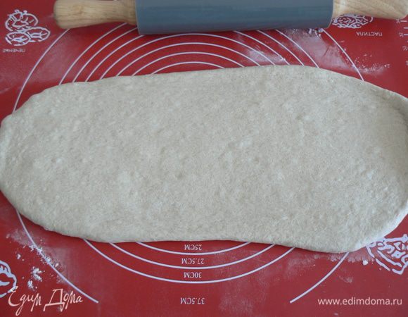 Тесто выложите, раскатайте скалкой  в длину 