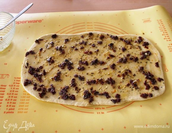 Раскатать в 1 см толщиной....обмазать смесью масла оливкового,чеснока (потереть или мелко нарезать) и соли крупной.....я добавила еще вяленых помидоров