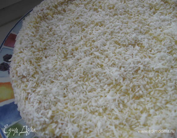 Смазать нижний корж кремом. Соединить с верхним. Так же поступить с верхней частью. Густо посыпать кокосовой стружкой верх торта и боковую часть. Поставить в холодильник на пару часов. Вынуть, разрезать порционно. 